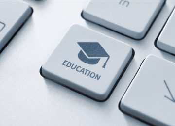 Button with graduation cap icon on a modern computer keyboard. Online education concept.